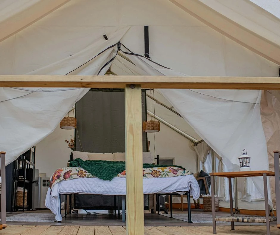 Styled canvas glamping tent with a real bed
